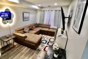 a living room with a couch and a tv at The Modern Suite - 2BR Close to NYC in Paterson +26 photos