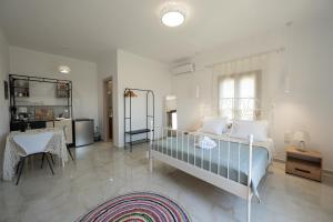 a bedroom with a bed and a desk and a table at Lenaki House in Ayía Kiriakí