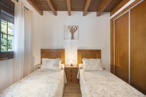 two beds in a room with white walls at Casa El Duque Zaira in Vejer de la Frontera +17 photos