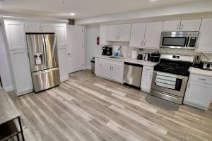 a kitchen with white cabinets and stainless steel appliances at The Modern Suite - 2BR Close to NYC in Paterson