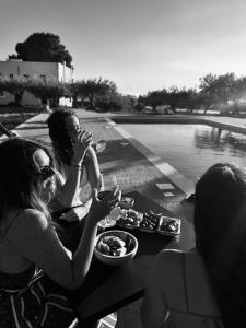 two women sitting at a table eating food and drinking wine at Stella del Rio in Naro