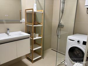 a bathroom with a sink and a washing machine at Green Coast 153a - by Ale Investa in Palasë