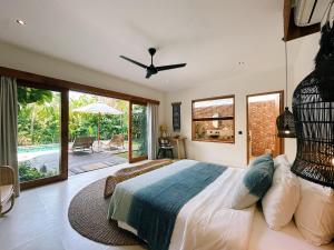 a bedroom with a large bed with a ceiling fan at Villa Caz a Bali in Canggu