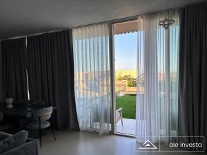 a living room with a large sliding glass door at Green Coast 153a - by Ale Investa in Palasë