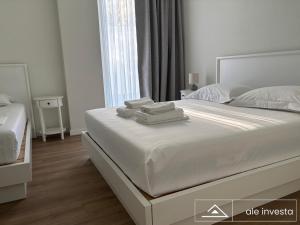 a bedroom with a large bed with two towels on it at Green Coast 153a - by Ale Investa in Palasë