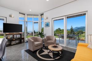 a living room with a flat screen tv and chairs at Apartments Bellavista in Matulji