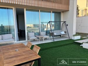 a patio with a table and chairs on the grass at Green Coast 153a - by Ale Investa in Palasë +4 photos