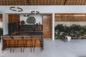 a kitchen with a counter and stools in a room at Villa Caz a Bali in Canggu +40 photos