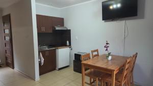 a kitchen and dining room with a table and a television at Apart Magda 2 in Rewal +3 photos