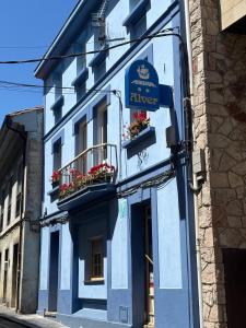 a blue building with a sign for a tavern at Pension Alver - El Refugio del Artista in Cudillero
