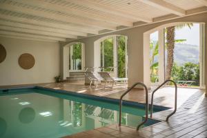 a swimming pool in a house with chairs and windows at Panorama Residence Öhlerhof in Lagundo