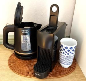 a black coffee maker and a cup on a table at B&B Wetterwille in Opeinde