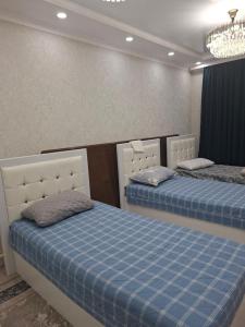 a bedroom with two beds and a chandelier at Guest house USMAN in Kazarman