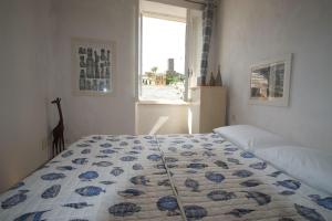 a bedroom with a bed with a blue and white quilt at Casa D'ambra in Vernazza