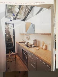 a kitchen with white cabinets and a wooden counter top at Casa D'ambra in Vernazza +14 photos