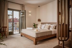 a bedroom with a bed and a balcony at JUNO Collection Residences in Pythagoreio