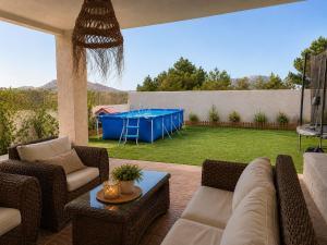 eine Terrasse mit Sofa und Tisch im Garten in der Unterkunft Ca Leo in Alicante
