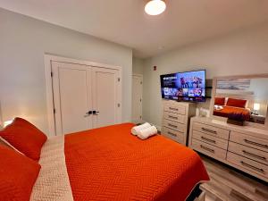 a bedroom with a bed and a flat screen tv at The Stylish Suite - 1BR with Free Parking in Paterson
