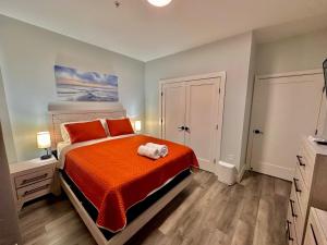 a bedroom with a bed with an orange bedspread at The Stylish Suite - 1BR with Free Parking in Paterson