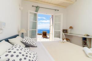 a bedroom with a bed with a view of the ocean at Cycladic Boungainvillea Home in Kalafatis
