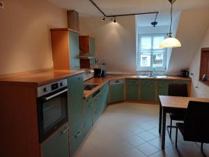 a kitchen with green cabinets and a table in it at Ferienwohnung Talblick in Horath
