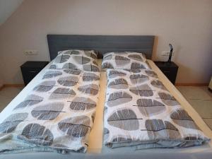 a bed in a bedroom with two pillows on it at Ferienwohnung Talblick in Horath