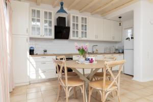 a kitchen with a wooden table and chairs at Cycladic Boungainvillea Home in Kalafatis