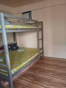 two bunk beds in a room with a wooden floor at Vilma Transient House in Bolinao