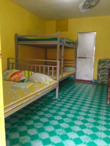 a bedroom with bunk beds with a green floor at Vilma Transient House in Bolinao