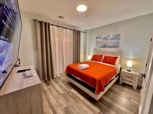 a bedroom with a bed with an orange blanket at The Stylish Suite - 1BR with Free Parking in Paterson