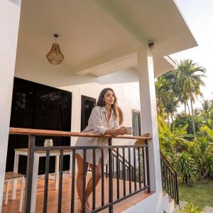 a woman standing on the balcony of a house at Garden Villa in Srithanu +13 photos
