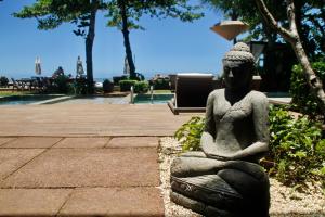 a statue of a woman sitting on the ground at Hotel Spa Nau Royal in Camburi