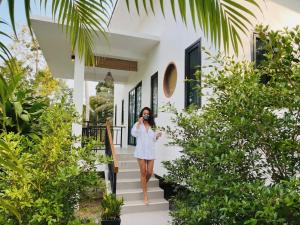 a woman taking a picture of a house at Garden Villa in Srithanu
