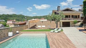 a villa with a swimming pool and a house at Majordoms Art in Sant Feliu de Pallerols