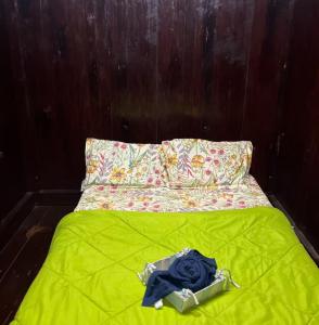 a bed with a green blanket and a blue rose on it at Heritage Haven in Changanācheri