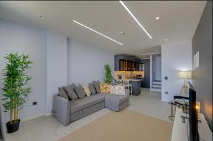 a living room with a gray couch and a kitchen at FOR LARGE FAMILIES, DUPLEX Vılla-304 in Çeşme