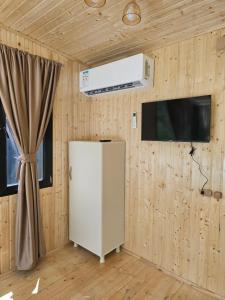 a kitchen with a refrigerator and a air compressor at Merisi Horizon in K'eda