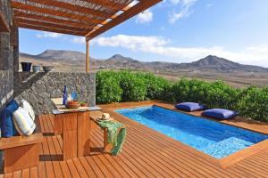 a pool on a deck with a view of the mountains at Casa San Luis in Pájara