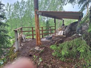 a dog sitting next to a wooden fence at Kalliotupa in Haapakylä