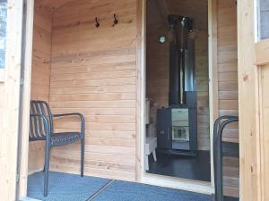 a wooden room with a stove and a chair in it at Kalliotupa in Haapakylä +1 photo