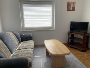 ein Wohnzimmer mit Sofa und Couchtisch in der Unterkunft Petit in Hatten