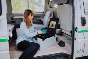 a woman is sitting in the back of a van at Camper Hipalán in San Sebastián de la Gomera