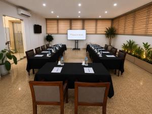 a conference room with tables and chairs and a screen at 그레이스 호텔 Grace Hotel & Residence in Hanoi