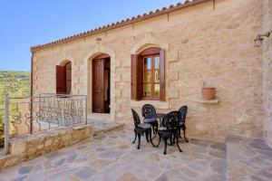 a patio with a table and chairs on a building at Villa Iremia in Nísi +33 photos