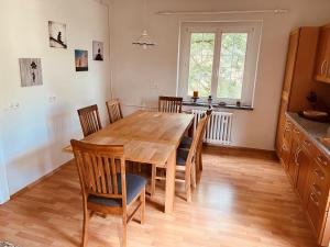 a dining room with a wooden table and chairs at Auszeit im Chursbachtal in Callenberg