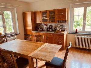a kitchen with a wooden table and a table and chairs at Auszeit im Chursbachtal in Callenberg +3 photos