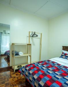 a bedroom with a bed with a plaid blanket at Naisula Home in Naivasha