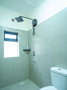 a bathroom with a shower with a toilet and a window at Naisula Home in Naivasha +3 photos