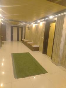 a large room with a green rug on the floor at Pragya inn hotel Haldwani in Haldwāni