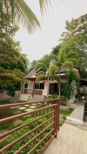 a house with a fence and palm trees at DonnRaqui's Hidden Zen in Iligan